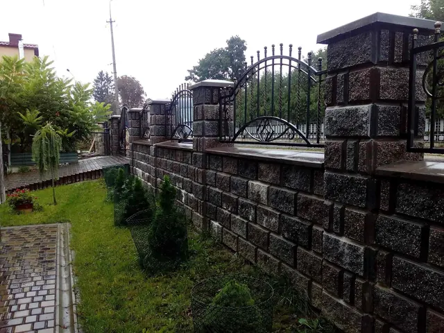Довгий паркан з різнокольорових декоративних блоків