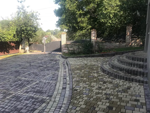 Подвір'я, вимощене бруківкою, з бордюрами